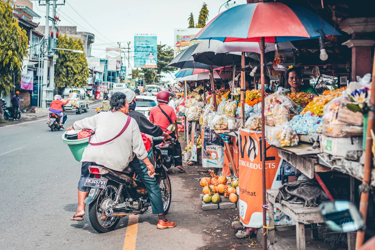Places of Indonesia Landscape Travel Photos 29 by Lynn Peiffer People call out orders from motorbikes at a roadside market for Hindu offerings in Bali, Indonesia.