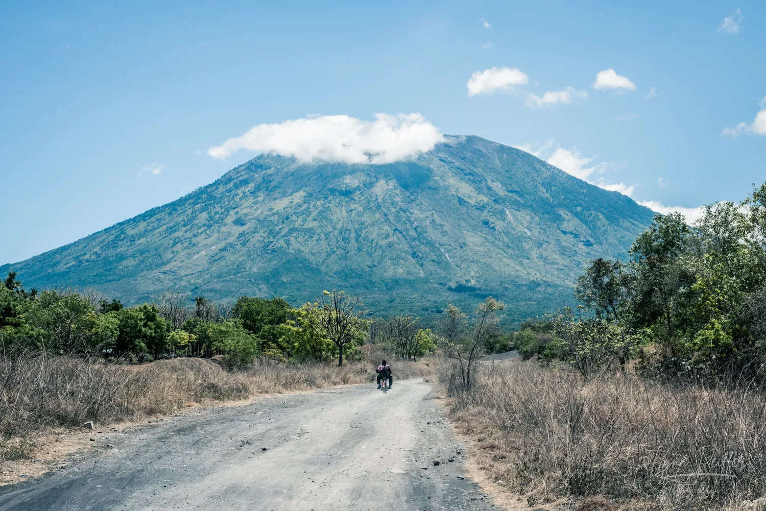 Places of Indonesia Landscape Travel Photos 32 by Lynn Peiffer A motorbike cruises along a dirt path near Gunung Agung, the largest volcano in Bali, Indonesia.